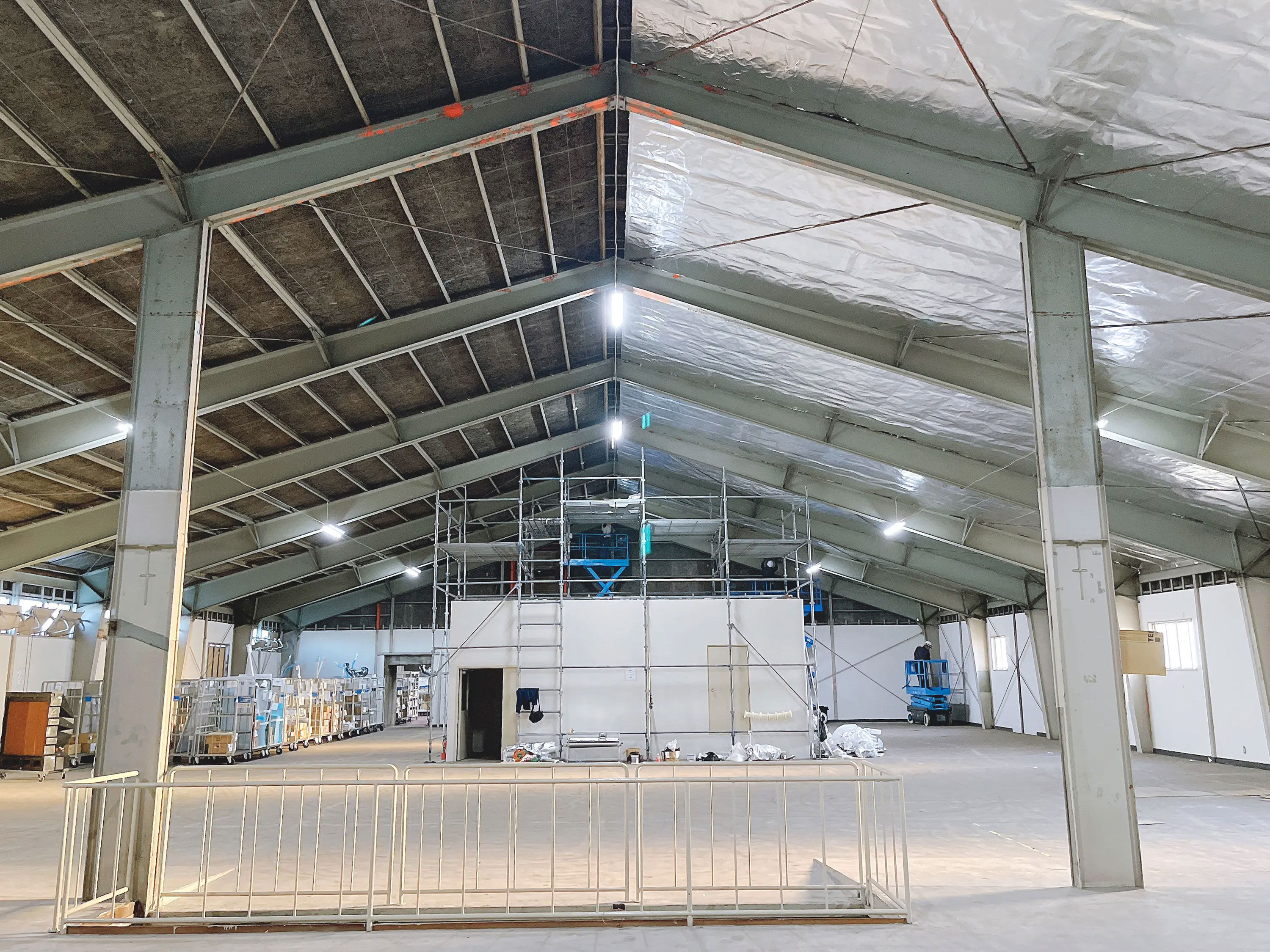Interior of a large unfinished building with exposed beams and scaffolding.