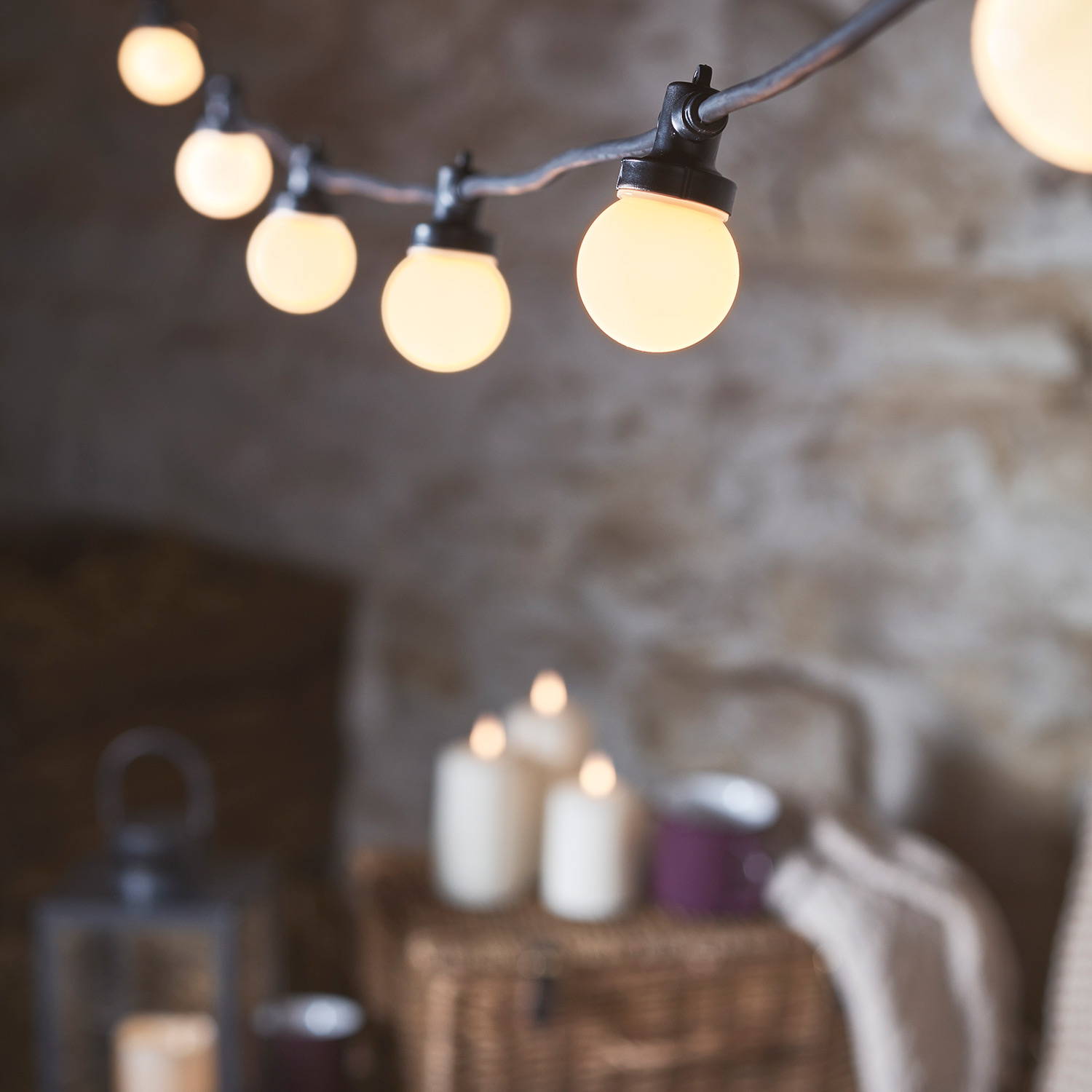 Frosted cap festoon lights in an autumn barn with LED candles in the background.