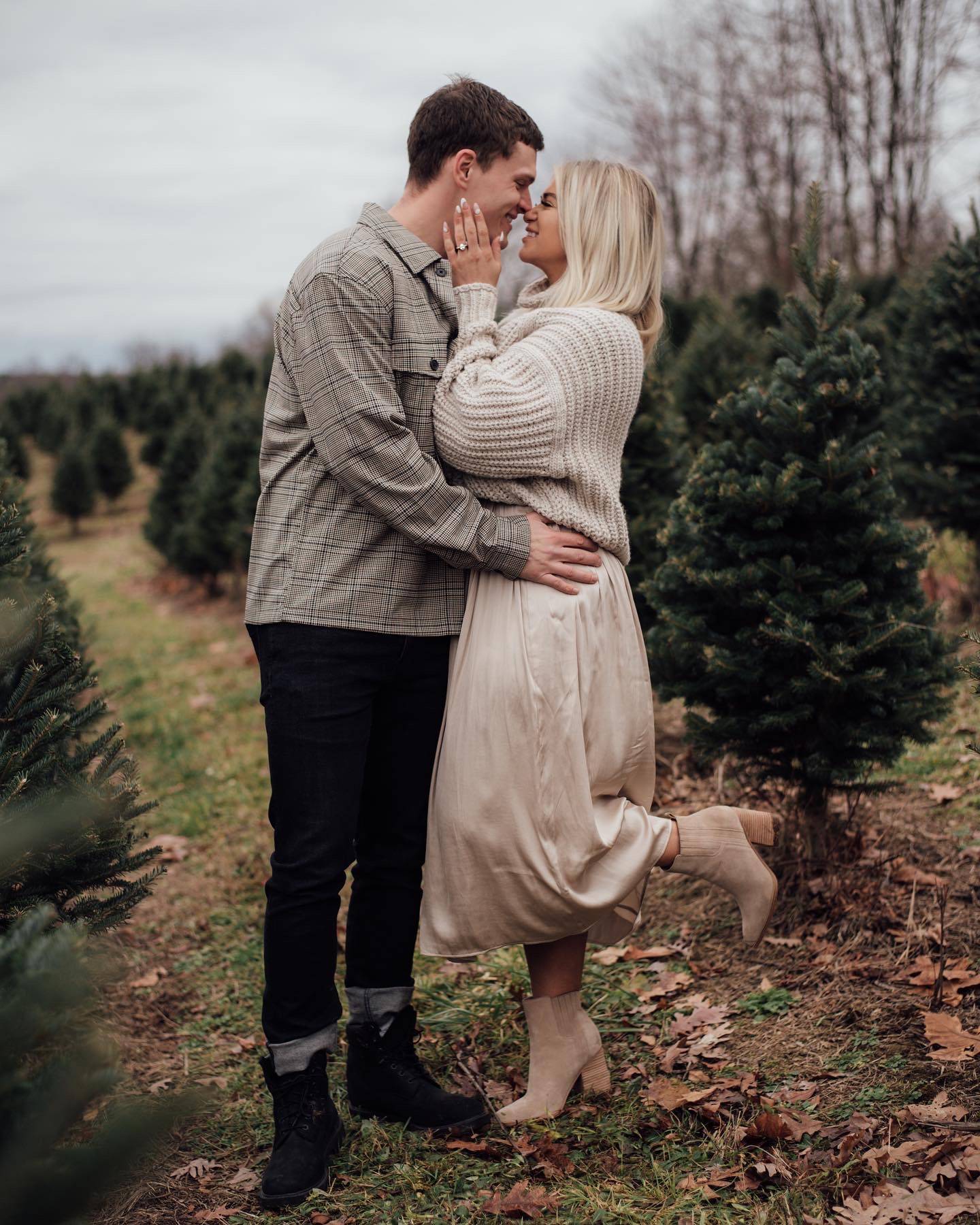 Henne Engagement Ring Couple James & Kelsey Share a Kiss Next to a Christmas Tree