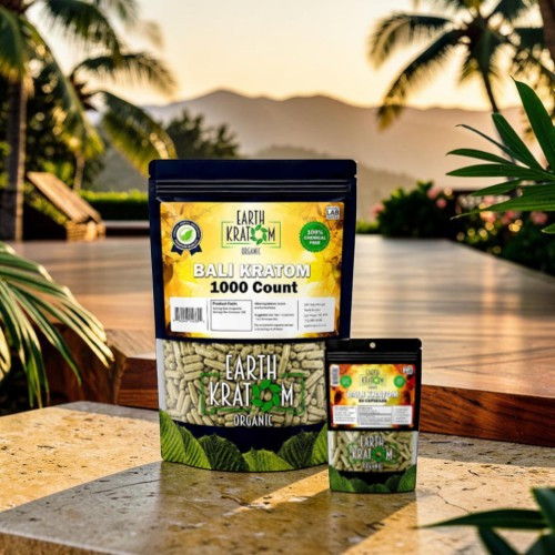 Bags of seeds displayed outdoors with palm trees and mountains in the background.