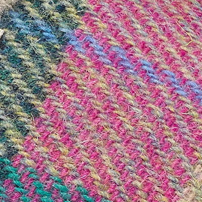Pink, teal and cream Harris Tweed fabric with multicoloured woven texture.