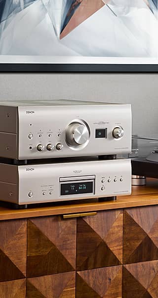 Silver audio equipment on a wooden surface with geometric design.