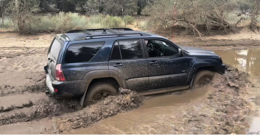 Dark blue Toyota 4Runner off-roading through deep mud pit wooded area Trevor's 2005 4 Runner Dixie musical horn gallery photo 2