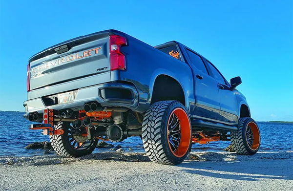 Front three-quarter Mauricio's blue Silverado RST with orange suspension and custom wheels photo 2