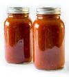 Preserve tomatoes by canning homemade sauce.