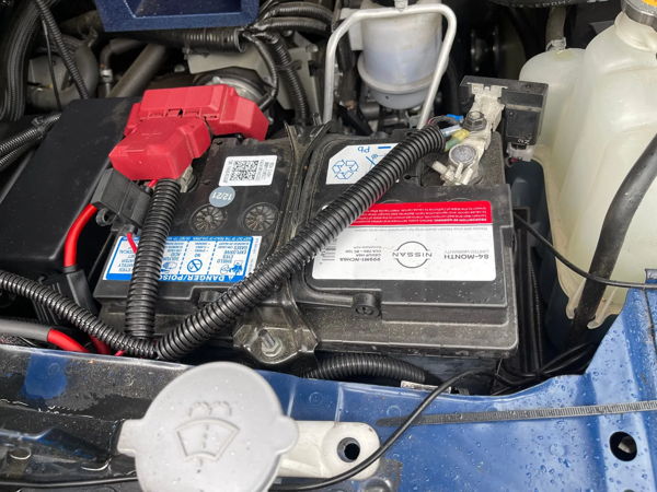 Engine bay Nissan battery red positive terminal cover wiring looms Jonathan's 2020 Nissan Titan Outlaw 228H train horn electrical gallery photo 3