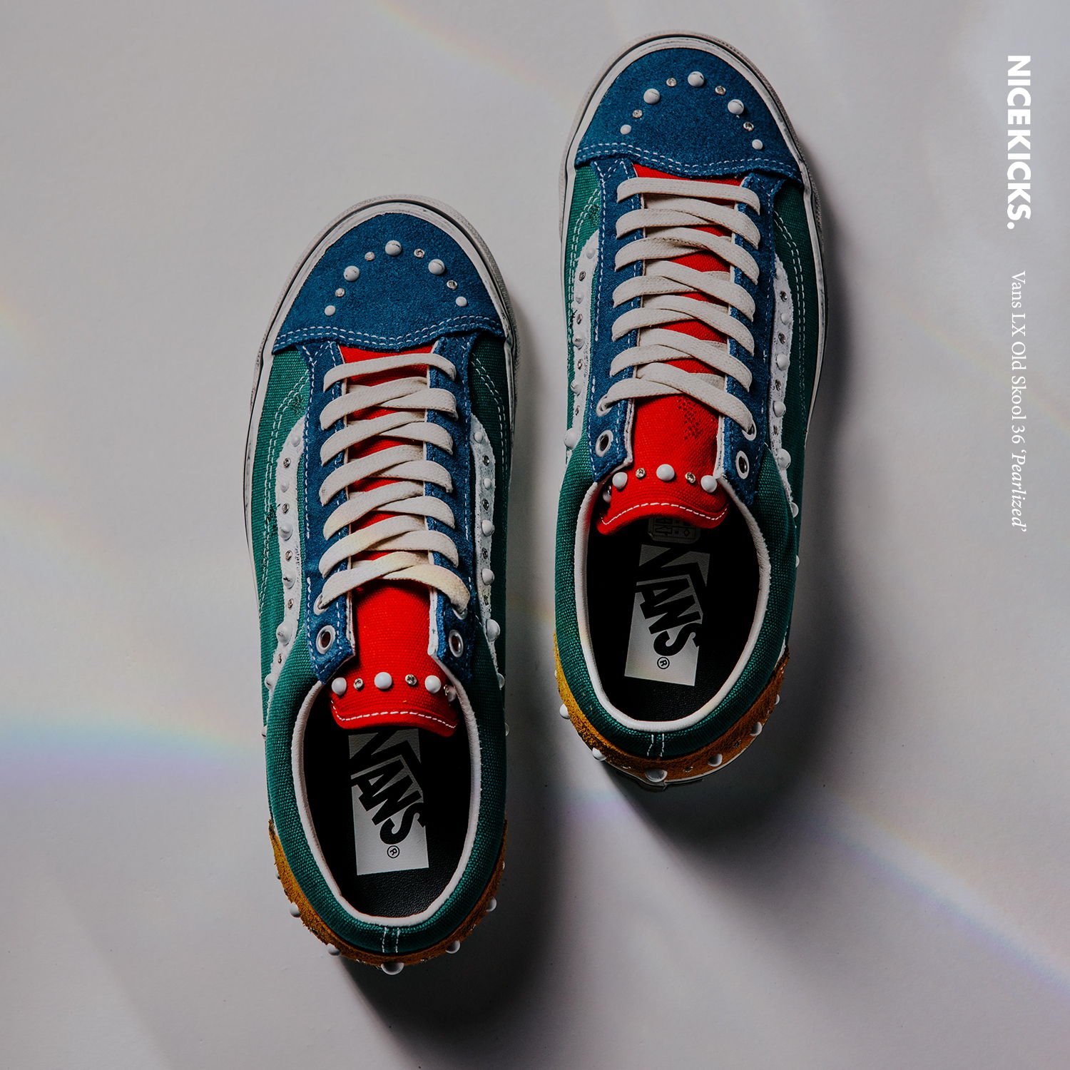 Colorful sneakers with blue, red, and green accents on a reflective surface.
