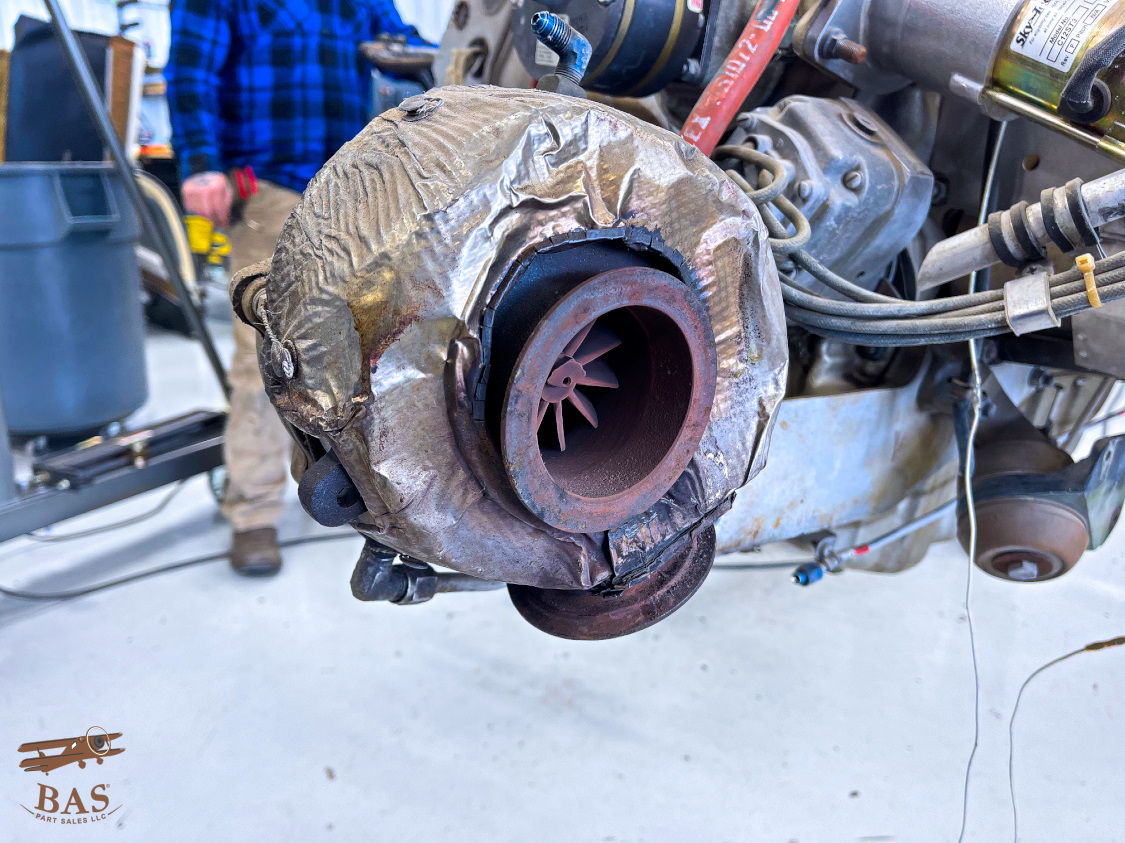 Close-up of a turbocharger with visible components and surrounding machinery.