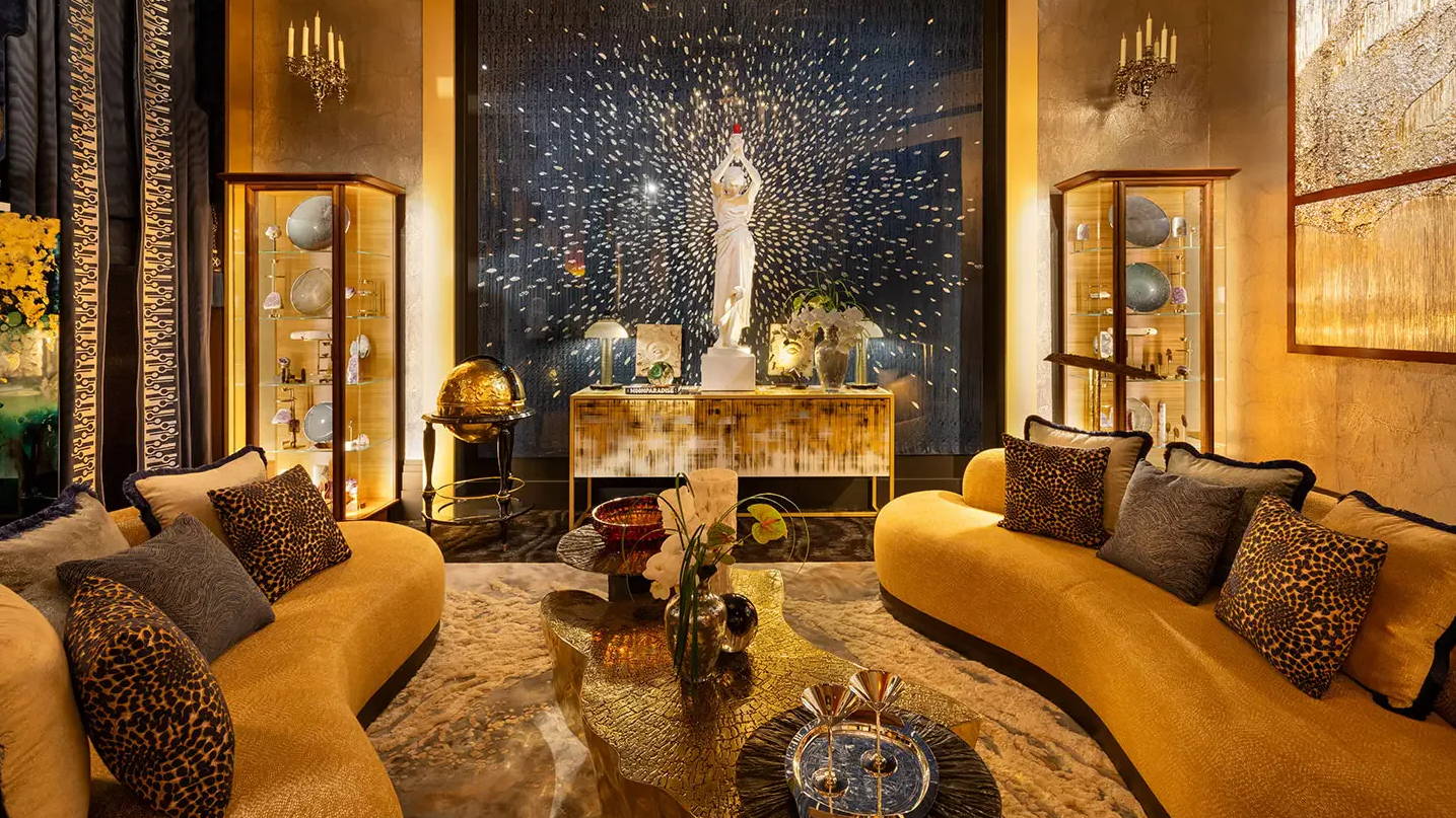 Luxurious living room with yellow sofas and decorative statue in the background.