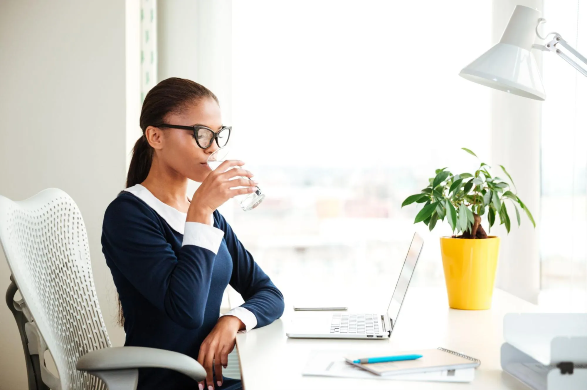 woman drinking water at desk