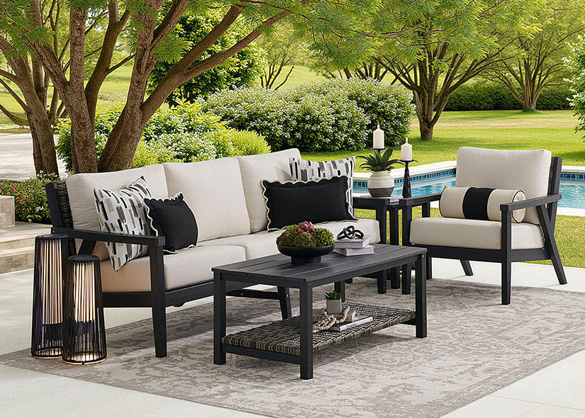Outdoor seating area with a sofa, chairs, and coffee table by a pool.