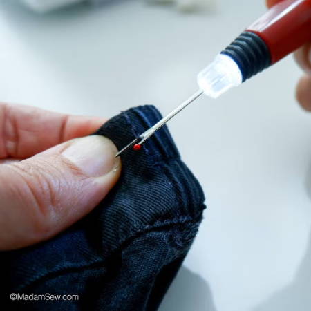 Using a seam ripper to take a seam out on a denim project