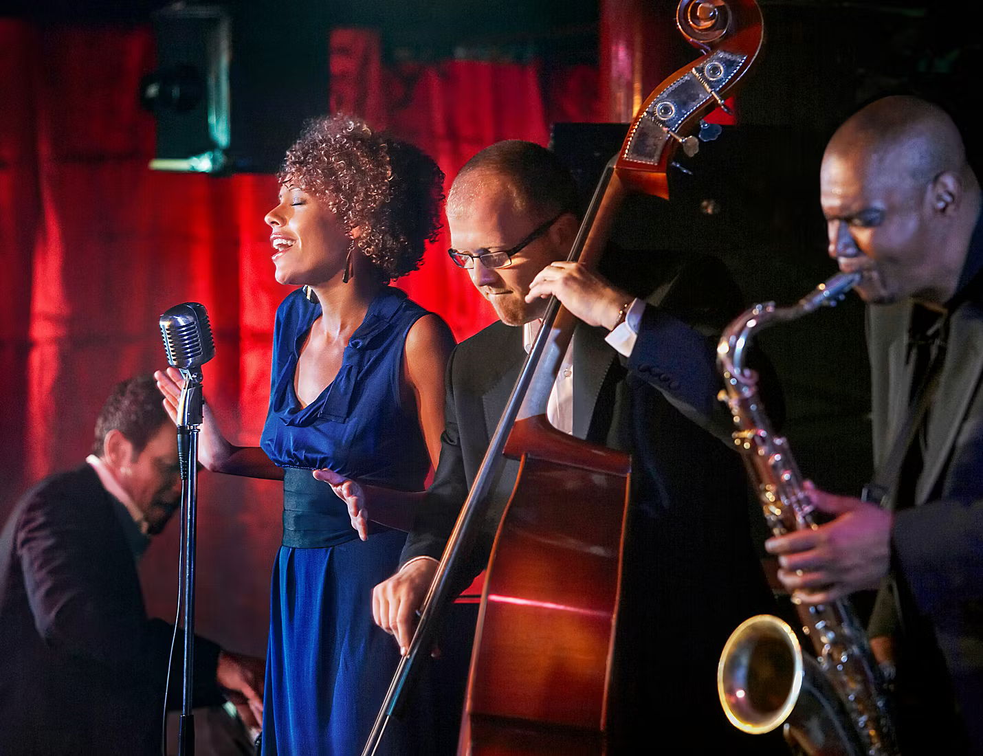 Musicians performing live, featuring a vocalist and various instruments.