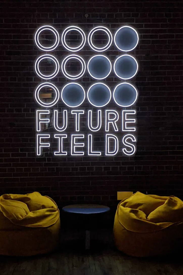 Future Fields neon logo sign and beanbag chairs