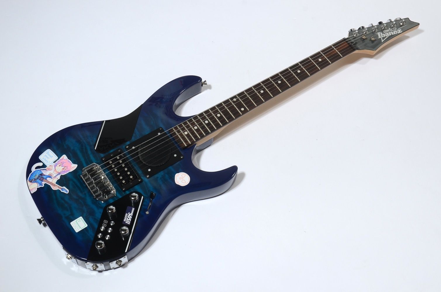 Electric guitar with blue finish and various stickers on its body.