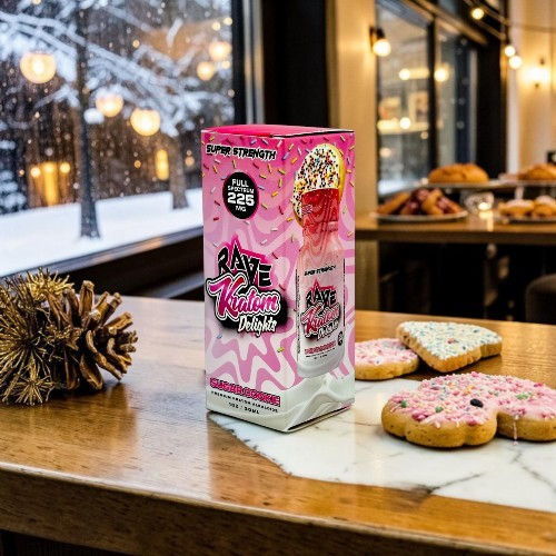 A colorful snack box beside decorated cookies on a wooden table.