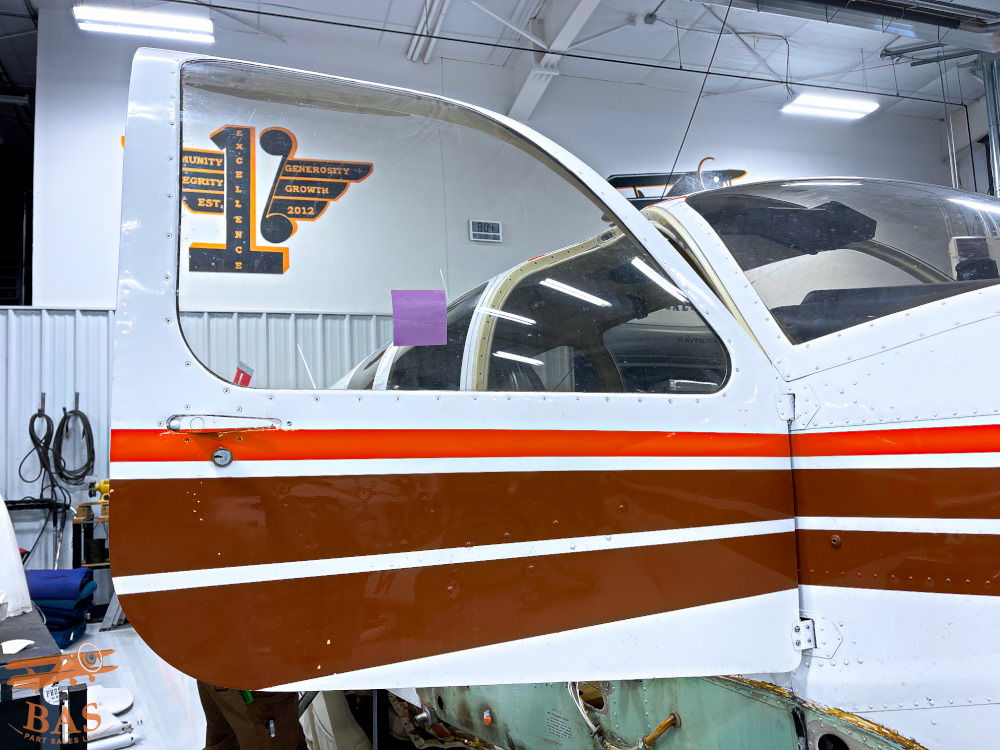 Close-up of an aircraft door with brown and white stripes in a hangar.