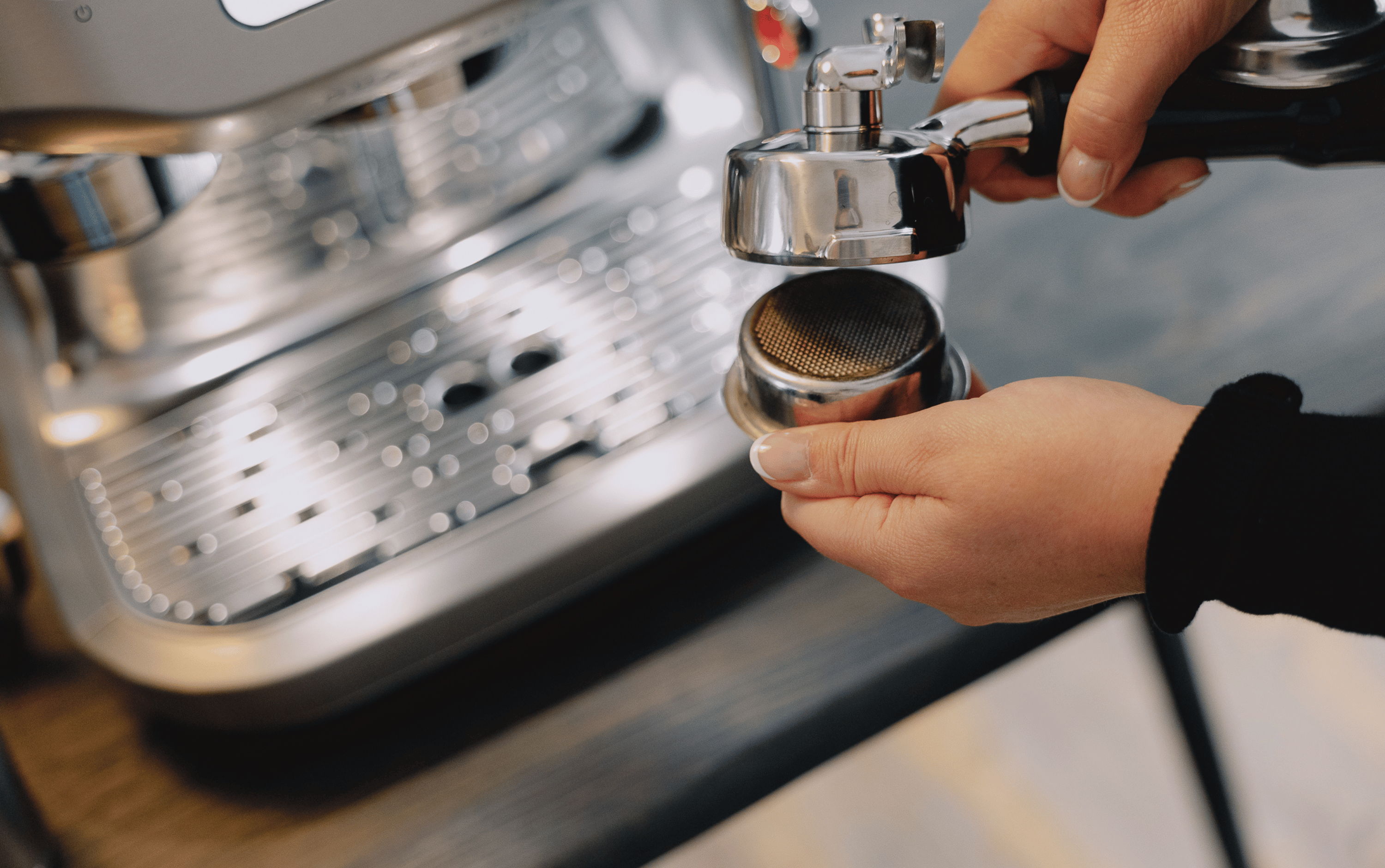 Onderhoud Sage Espresso Machine - persoon haalt basket uit portafilter