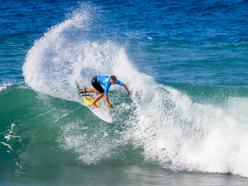 Surfer performing a trick on a wave in the ocean.