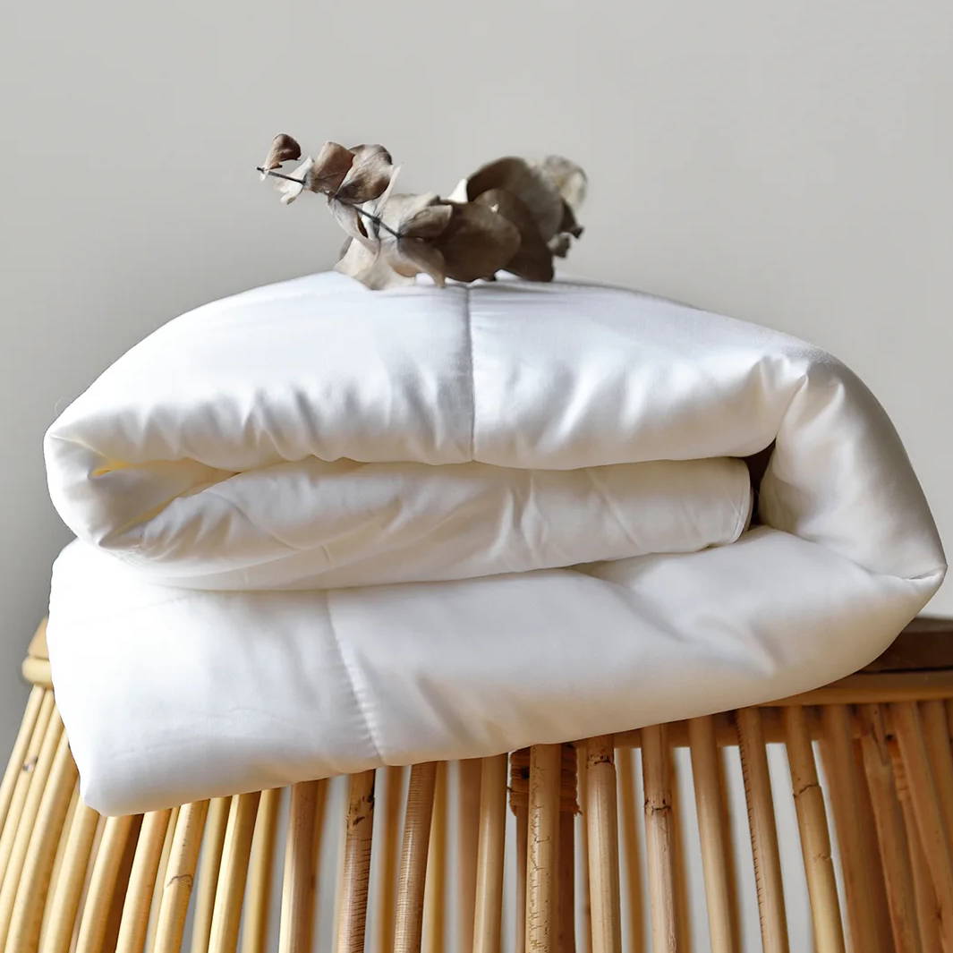 duvet insert folded and placed on a rattan stool