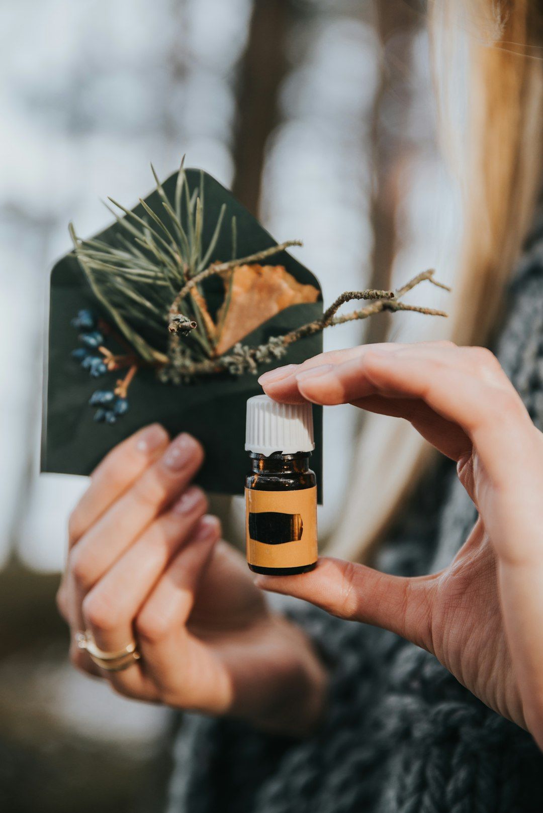 a woman holding a bottle of essential oil