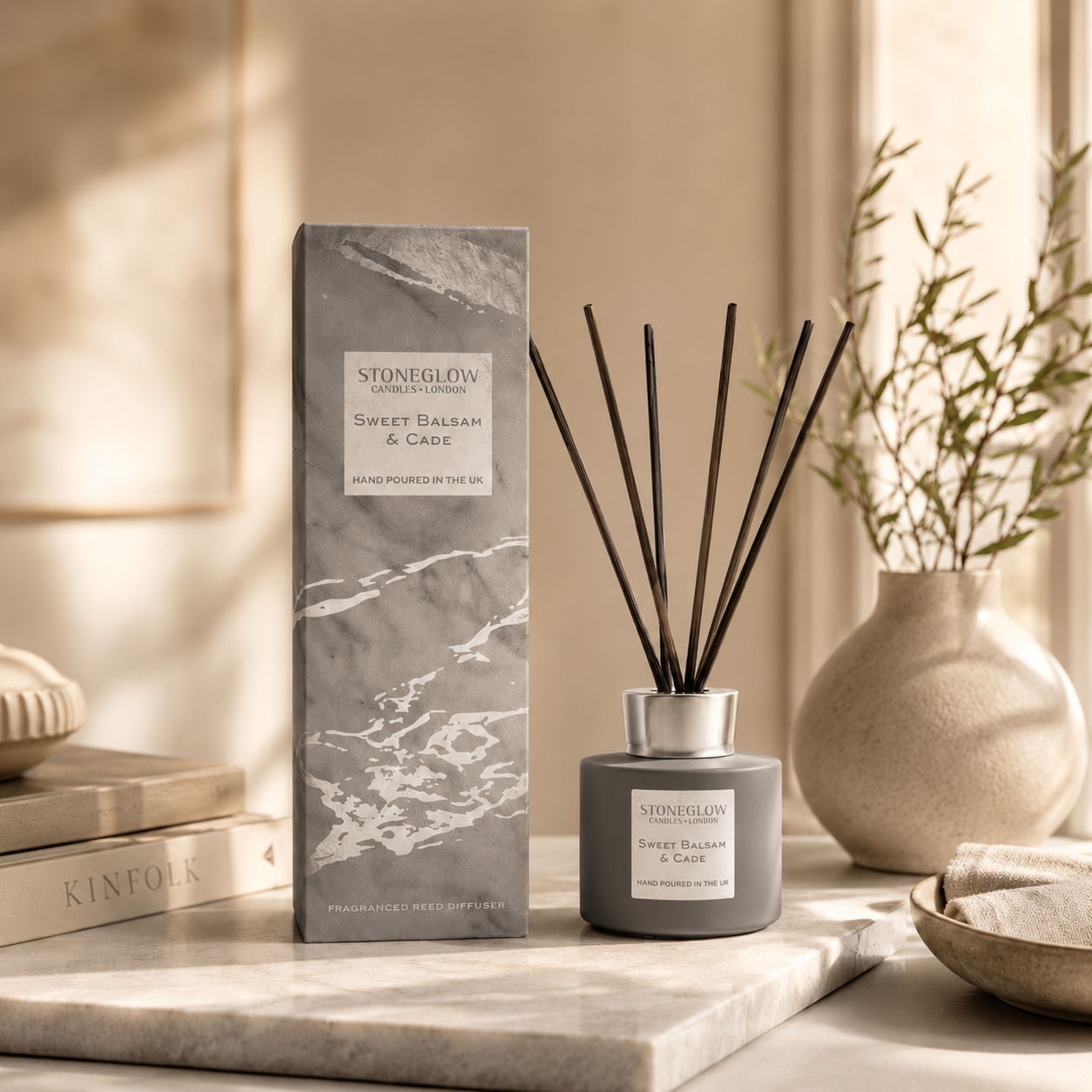 A decorative aroma diffuser with reeds, accompanied by a stylish box and vase.