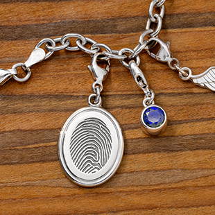sterling silver oval fingerprint charm bracelet with blue birthstone charm and angel wing charm