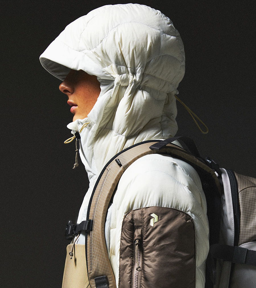 Person wearing a white puffy jacket and hood, side profile.