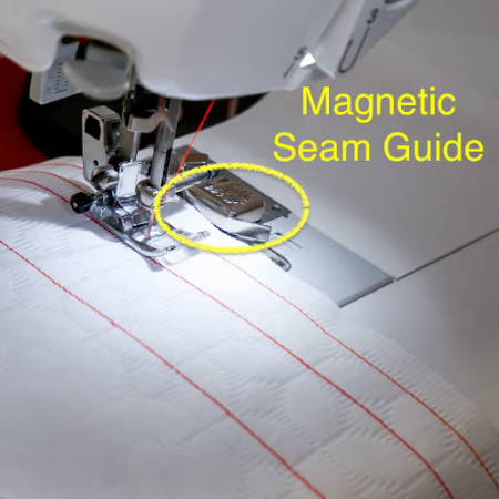 Magnetic seam guide guiding white fabric
