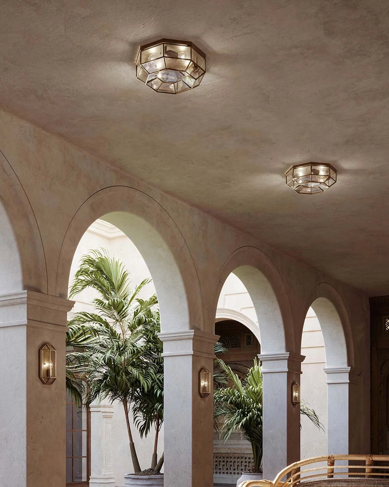 Arched corridor with ceiling lights and potted plants.