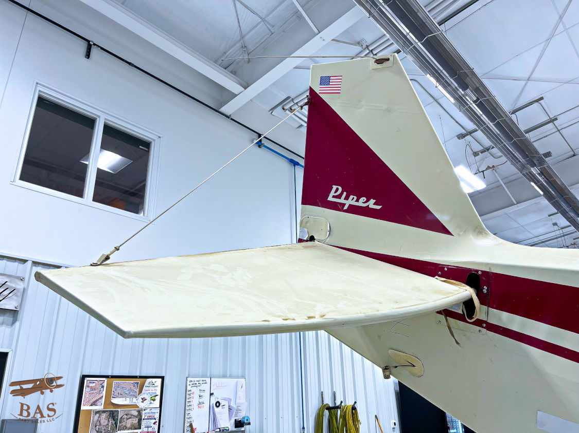 Tail section of an aircraft with a red and white design.