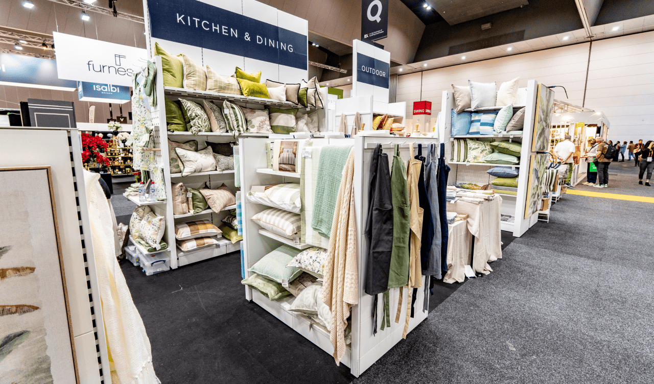 Showroom display with various home textiles and decorative items on shelves.