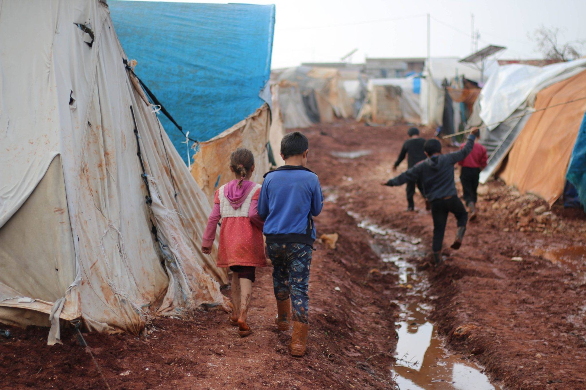 Refugee children in a muddy camp