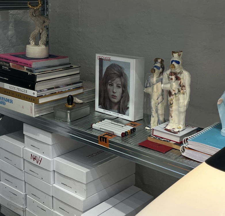 Books and decorative items on a glass shelf, including a photo frame.