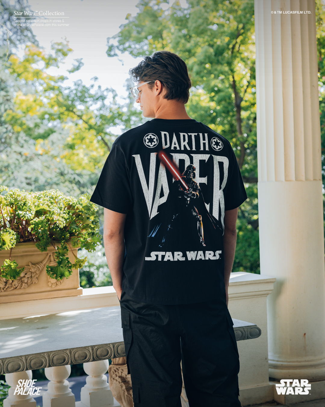 Person wearing a black Darth Vader Star Wars t-shirt, standing outdoors.