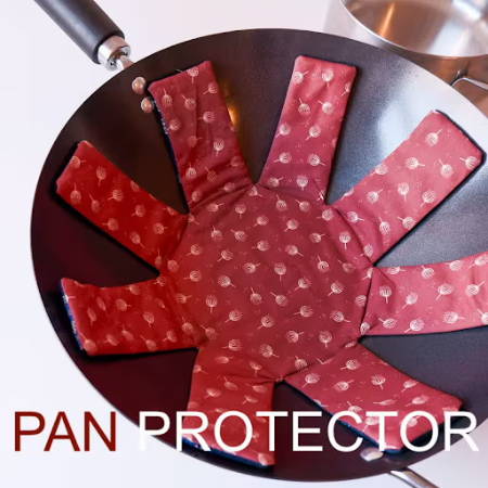 A pan with a diy pan protector, sewn out of dark red fabric