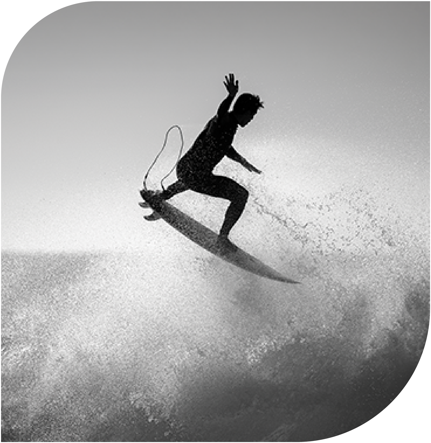 Silhouette of a surfer jumping over a wave in black and white.