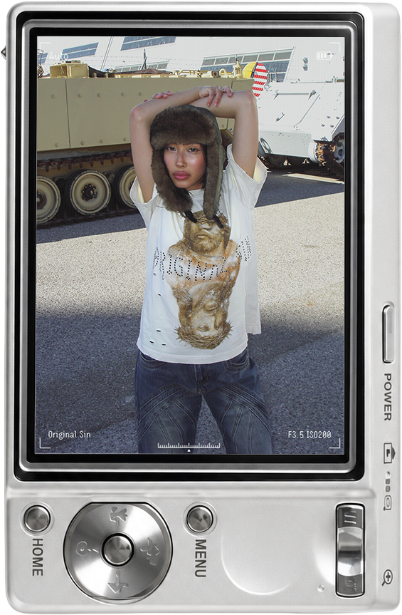 A person wearing a t-shirt and hat poses in an outdoor setting.