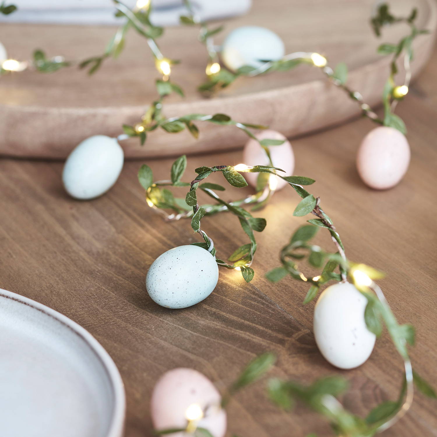 Egg micro garland close up on a wooden dining table.