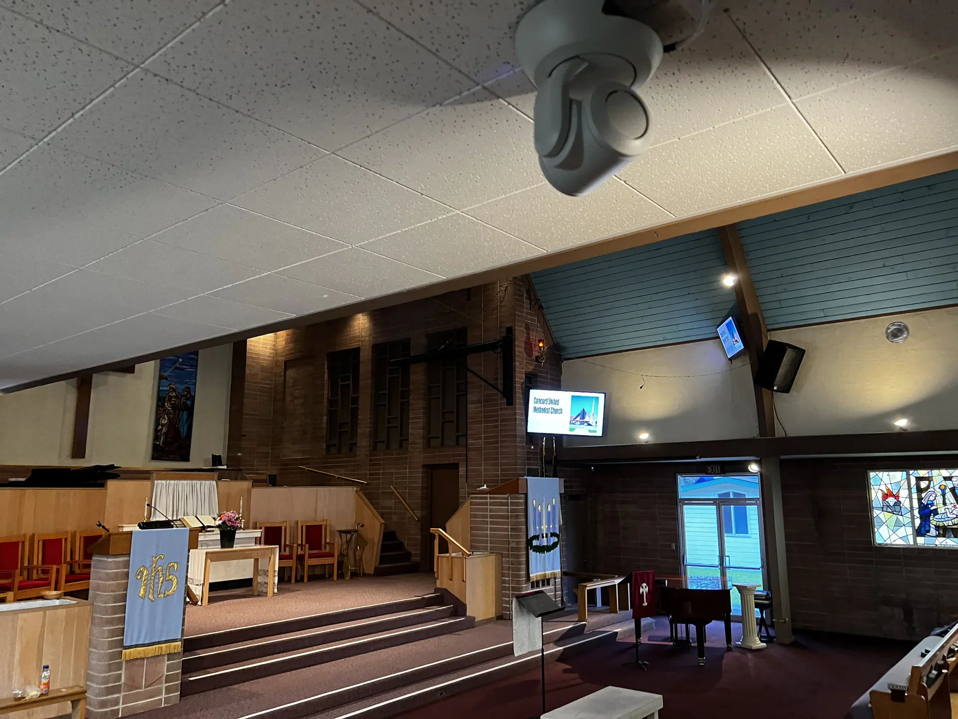 Interior of a church with seating and audio-visual equipment visible.