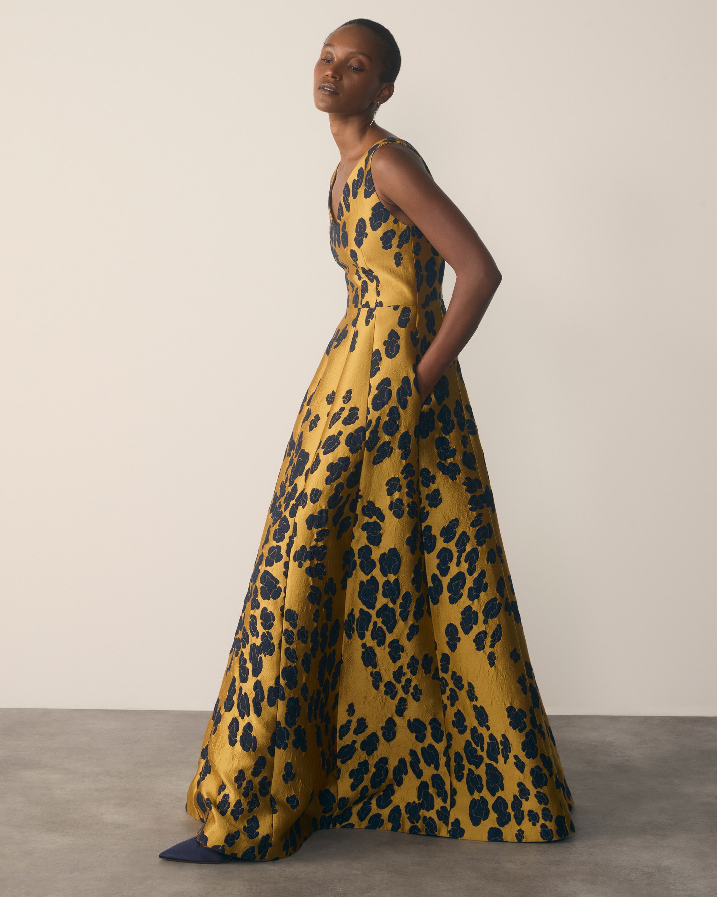 Model wearing gold and navy Marsella maxi gown