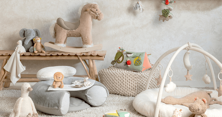 A cozy nursery with toys, cushions, and a rocking horse.