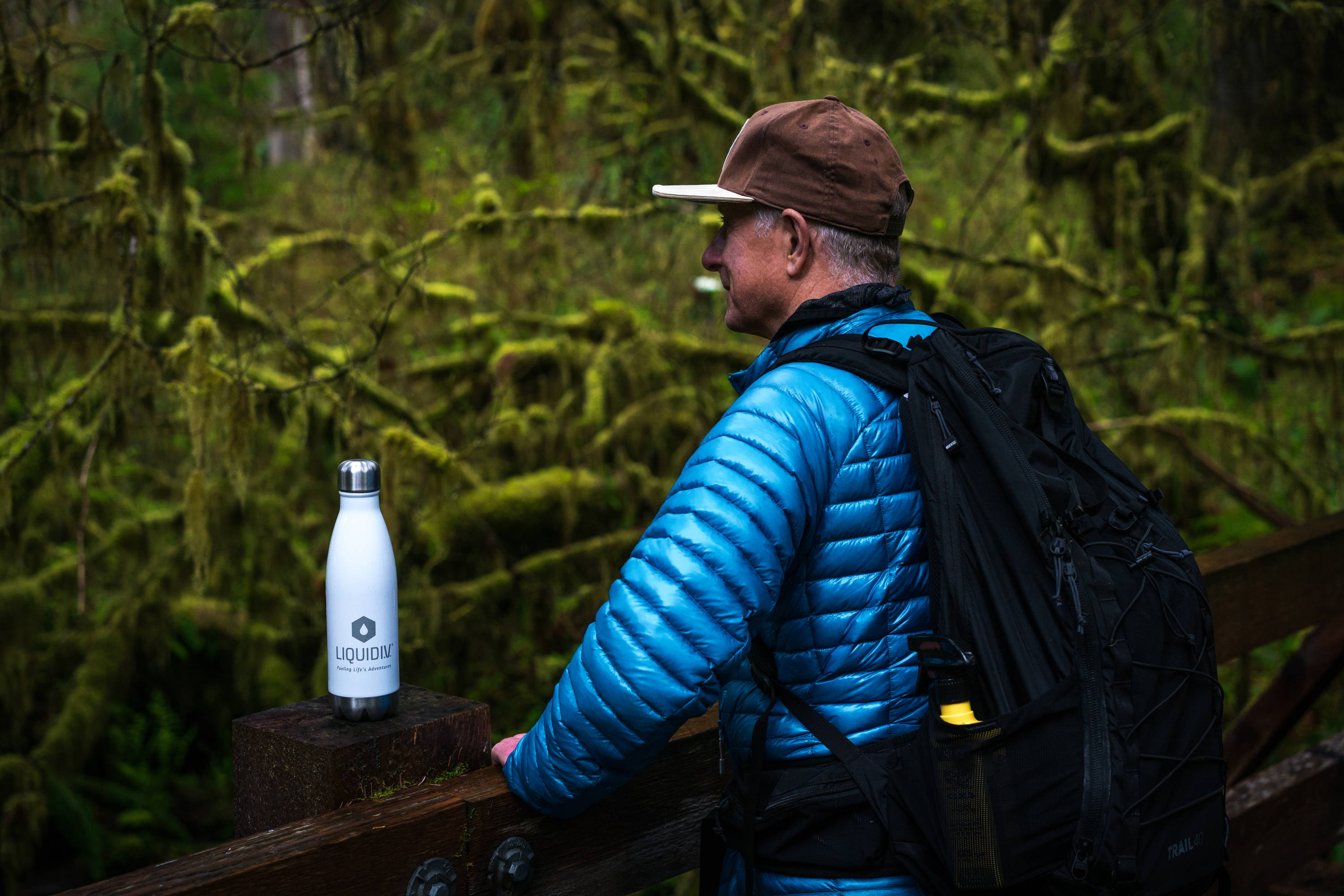 An outdoor enthusiast stands next to his Liquid IV water bottle.