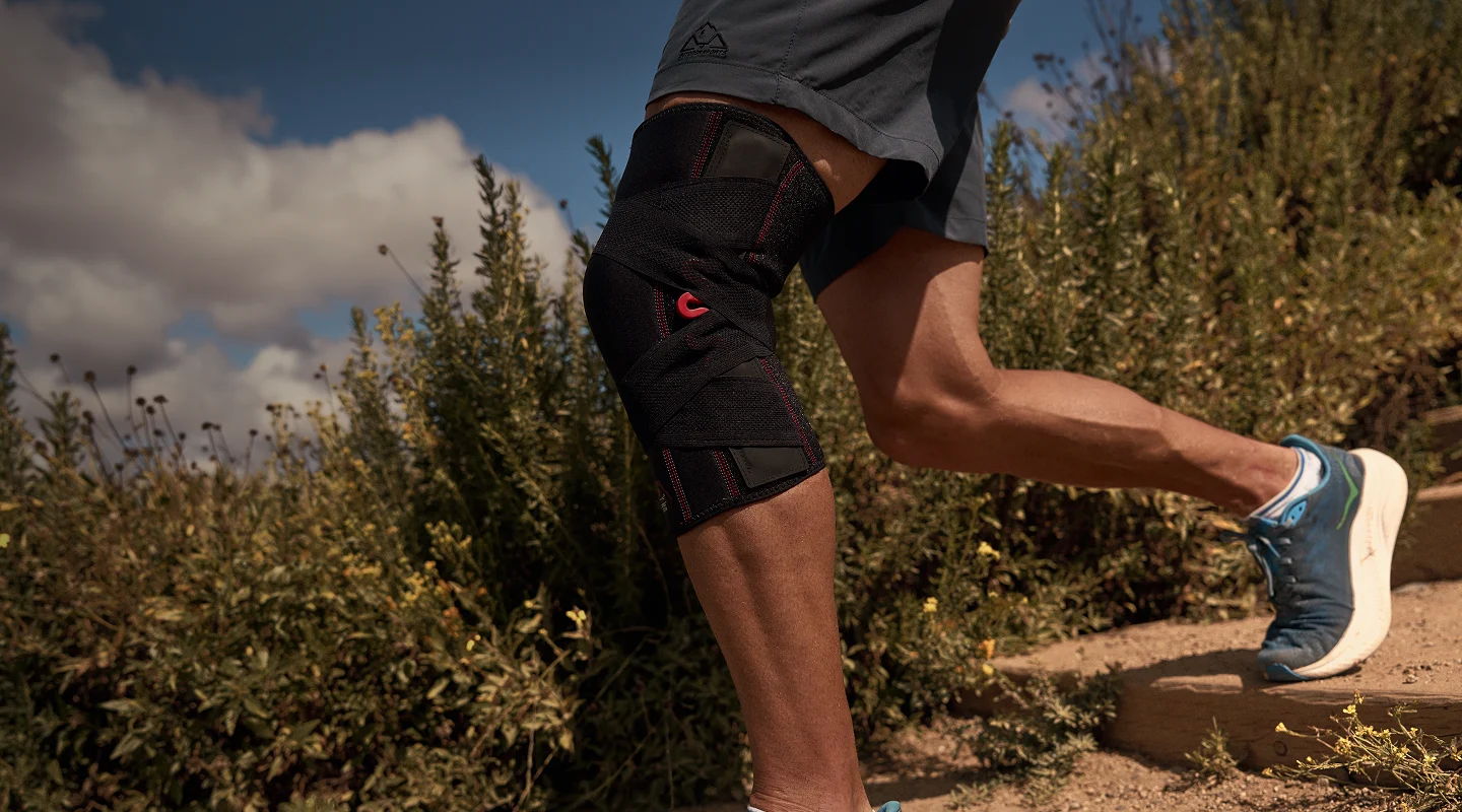Person running on a trail, wearing athletic shorts and sneakers.