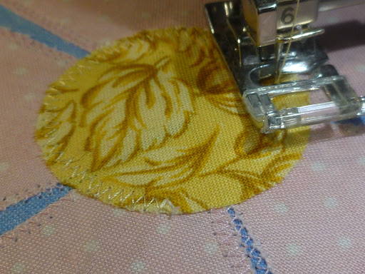 Using zig-zag stitch to applique flower centers on floral quilt
