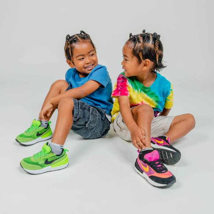 two young boys sitting wearing nike shoes