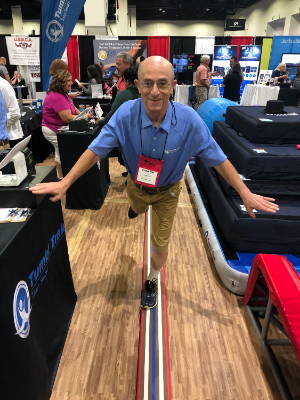 Coach Leonard Isaacs demonstrates by standing on the Laser Balance Beam