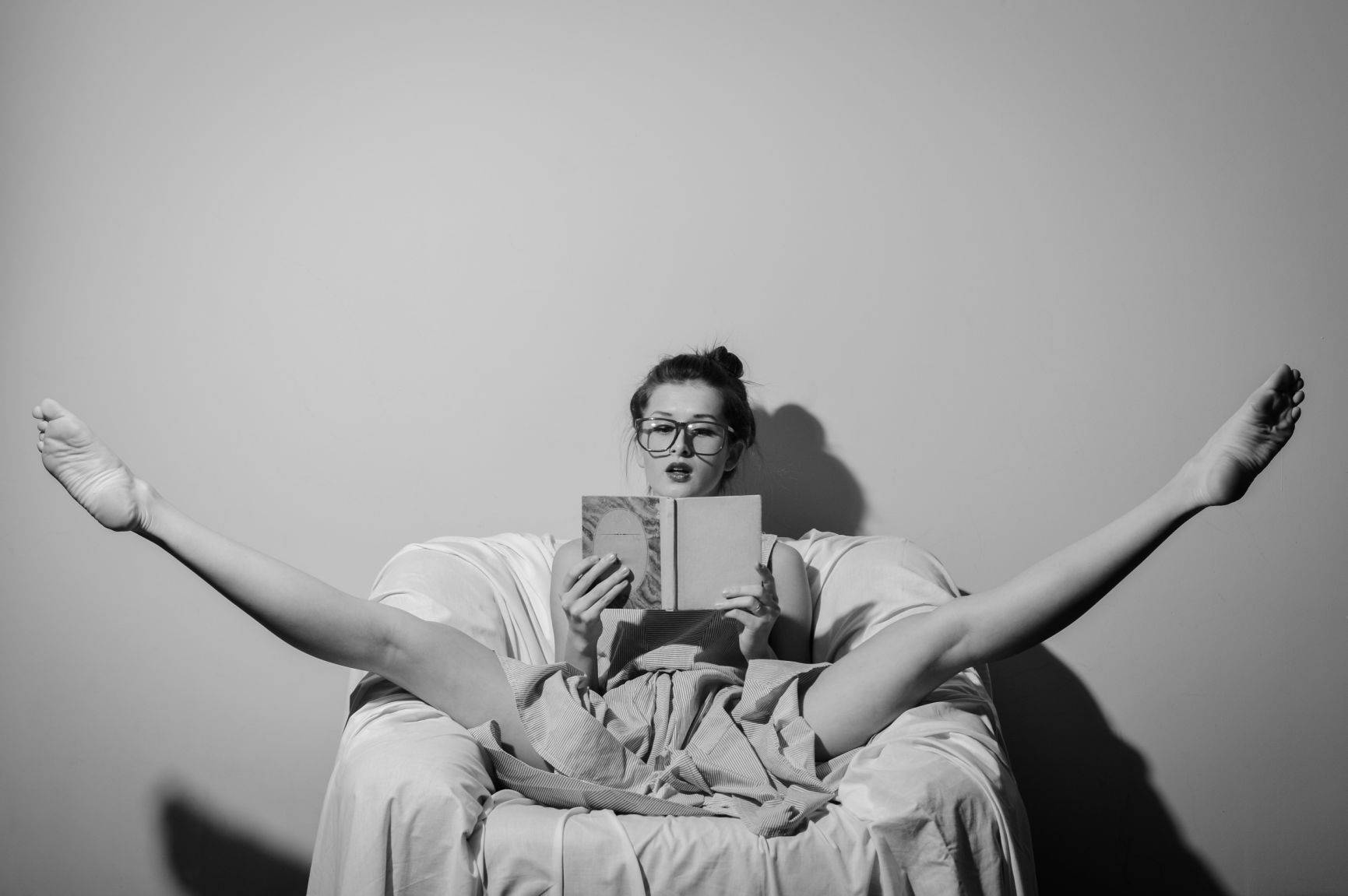 A woman sitting in a yoga pose with a book open in front of her about cbd fueled sex dreams