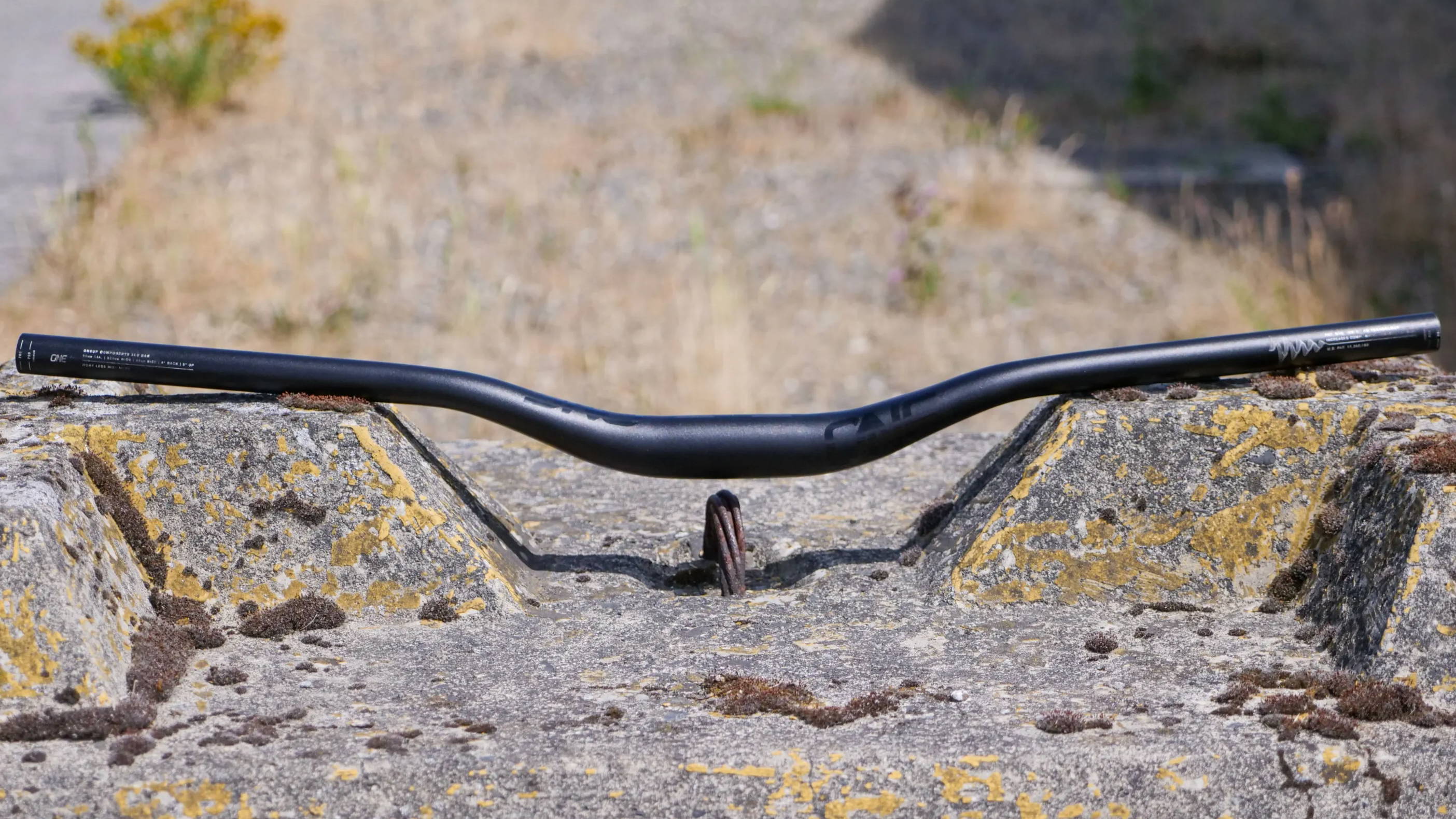 oneup components aluminum handlebars set on a concrete jersey barrier