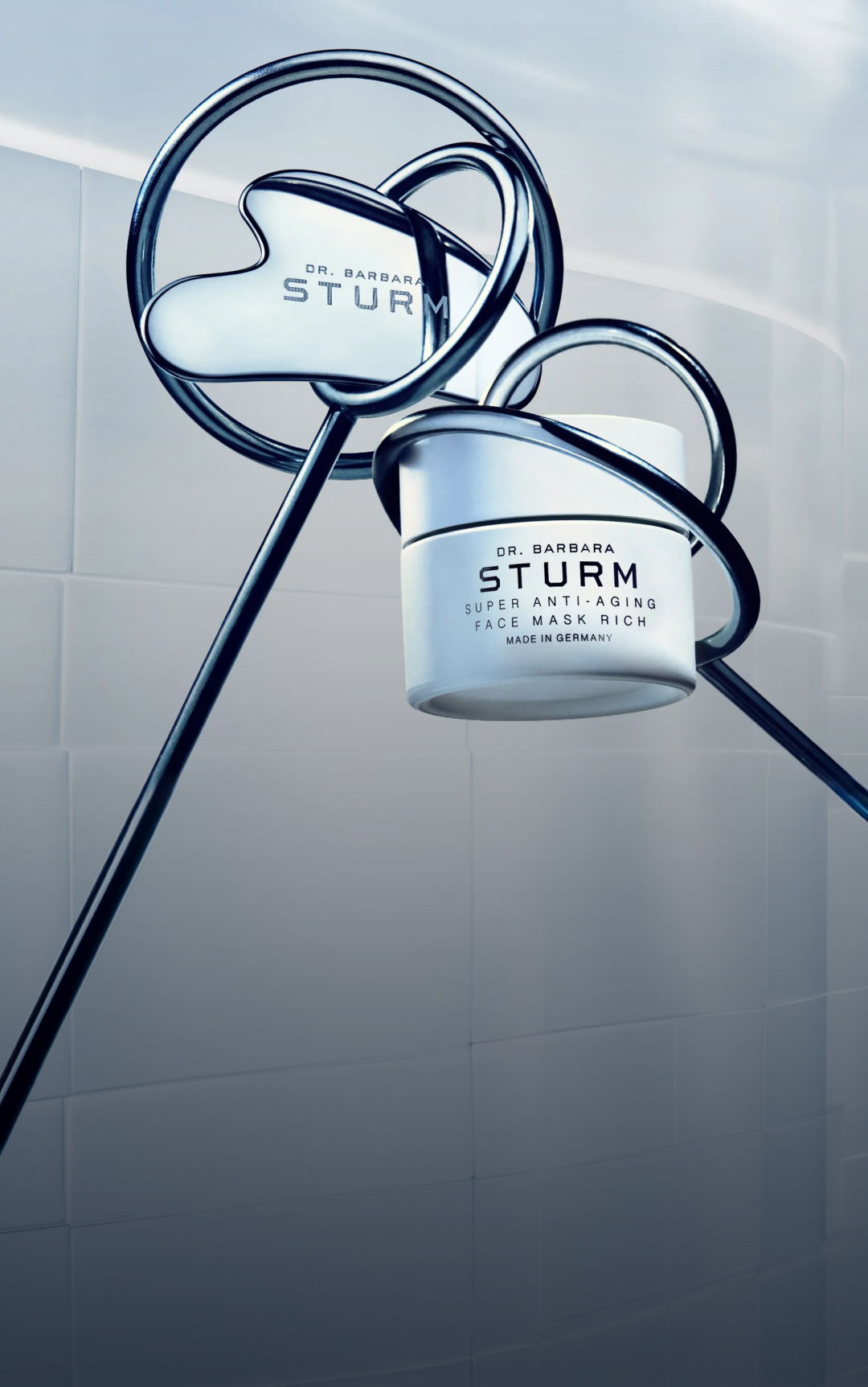 A skincare product by Dr. Barbara Sturm displayed with decorative metal loops.